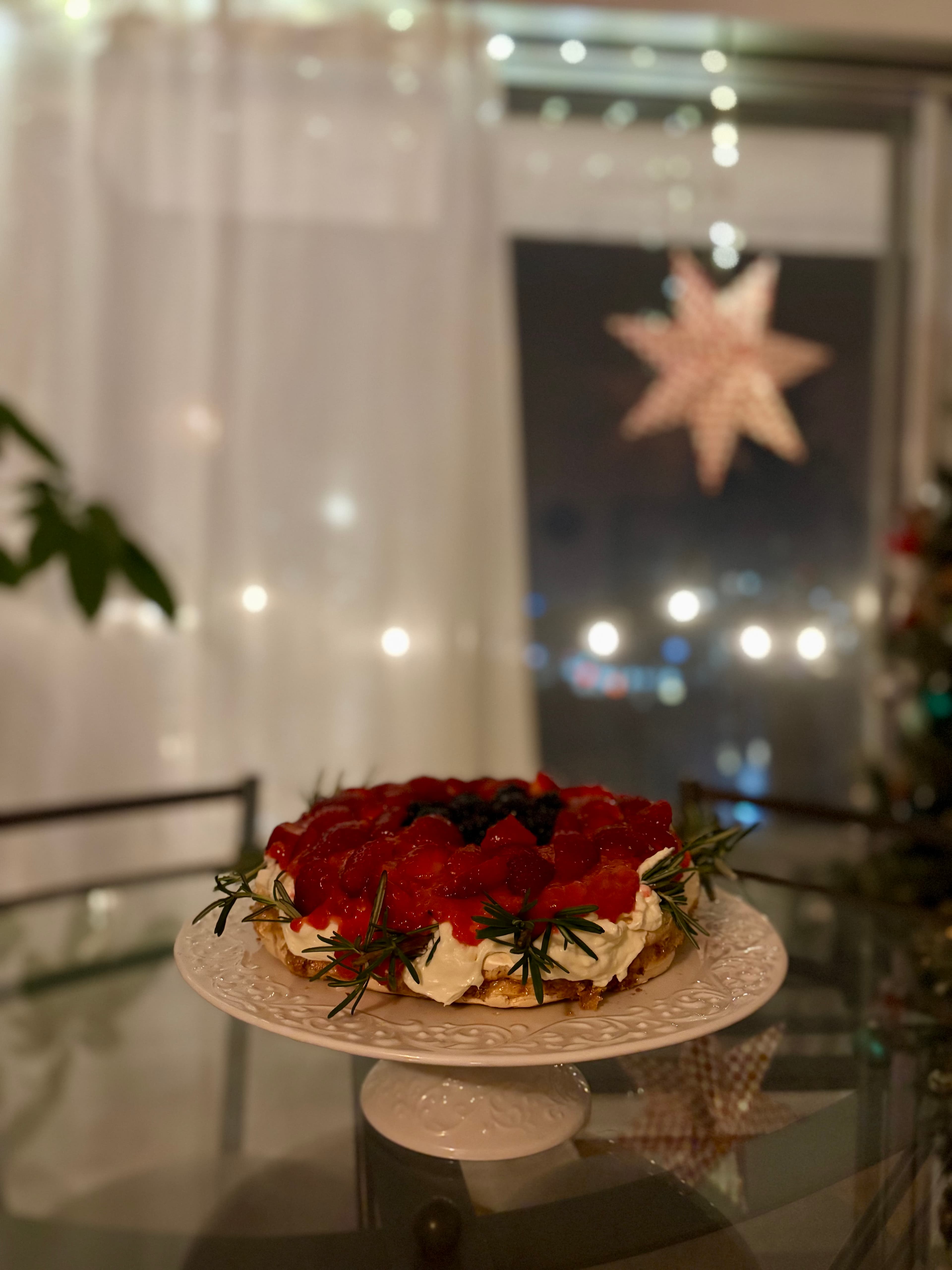 Pavlova cake topped with cream and fruit